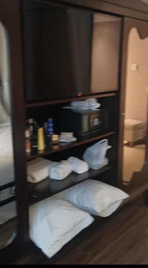 Buona Vitta Gramado Resort & Spa By Gramado Parks Zewnętrze zdjęcie The photo shows a piece of furniture, likely a shelving unit or cabinet, with several items on it. There is a television mounted on top. Below the TV, there is a microwave and a small safe. The shelves contain various toiletries and personal care pro
