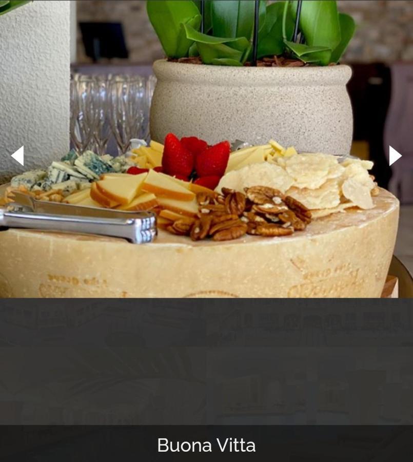 Buona Vitta Gramado Resort & Spa By Gramado Parks Zewnętrze zdjęcie The photo displays a beautiful cheese platter. It features a large round cheese wheel as the base, surrounded by various types of cheeses including soft and hard varieties. There are also some crackers or crisps, along with nuts, particularly pecans.