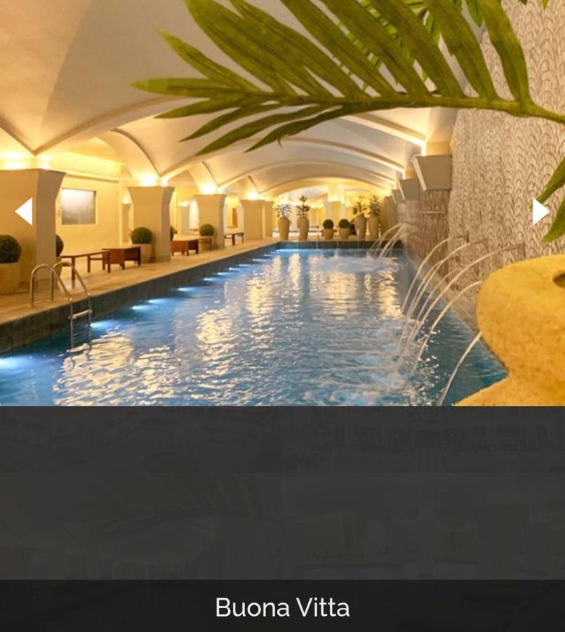 Buona Vitta Gramado Resort & Spa By Gramado Parks Zewnętrze zdjęcie The photo depicts an elegant indoor swimming pool area. The pool is illuminated with lights along its edge, and there are gentle water features creating a calming atmosphere. The ceiling has an arched design, and the space is decorated with plants an