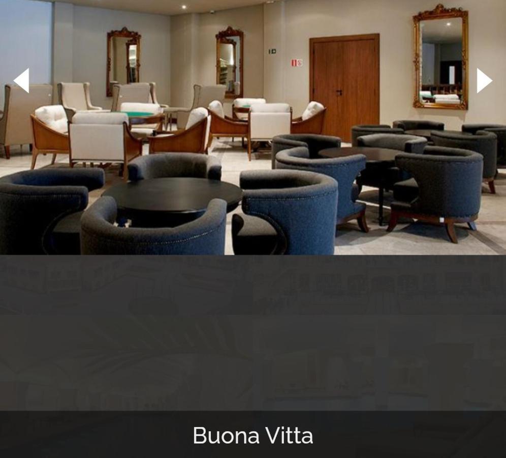 Buona Vitta Gramado Resort & Spa By Gramado Parks Zewnętrze zdjęcie The photo shows a modern, elegantly designed lounge or waiting area. It features several circular seating arrangements with dark blue armchairs surrounding black tables. In the background, there are light-colored lounge chairs and a wooden door leadi