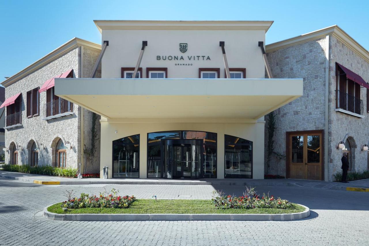 Buona Vitta Gramado Resort & Spa By Gramado Parks Zewnętrze zdjęcie The photo shows a modern building with a prominent entrance marked by a large awning. The facade features a mix of stone and stucco materials, giving it an elegant and contemporary look. The name "BUONA VITTA" is displayed prominently above the entra