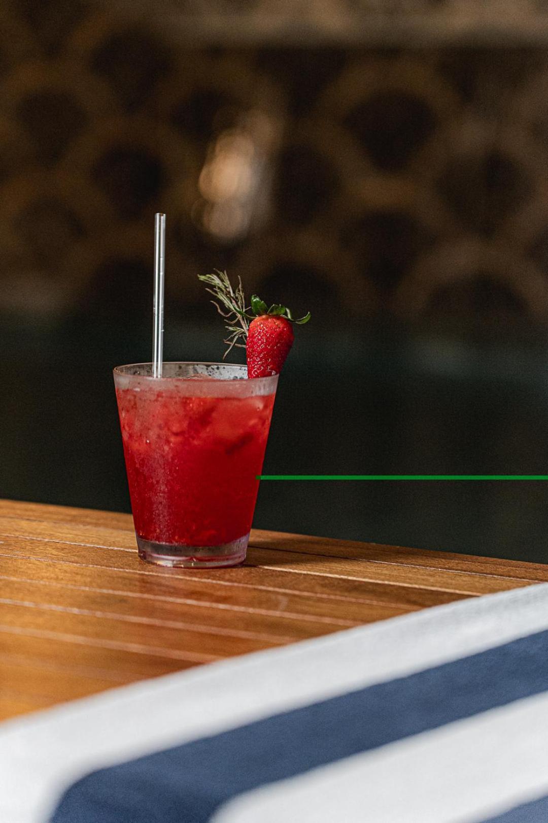 Buona Vitta Gramado Resort & Spa By Gramado Parks Zewnętrze zdjęcie The photo shows a refreshing cocktail served in a transparent glass. The drink is vibrant red, suggesting it may be made with strawberries or a similar fruit. It features a straw and a garnish of a fresh strawberry on the rim of the glass, along with
