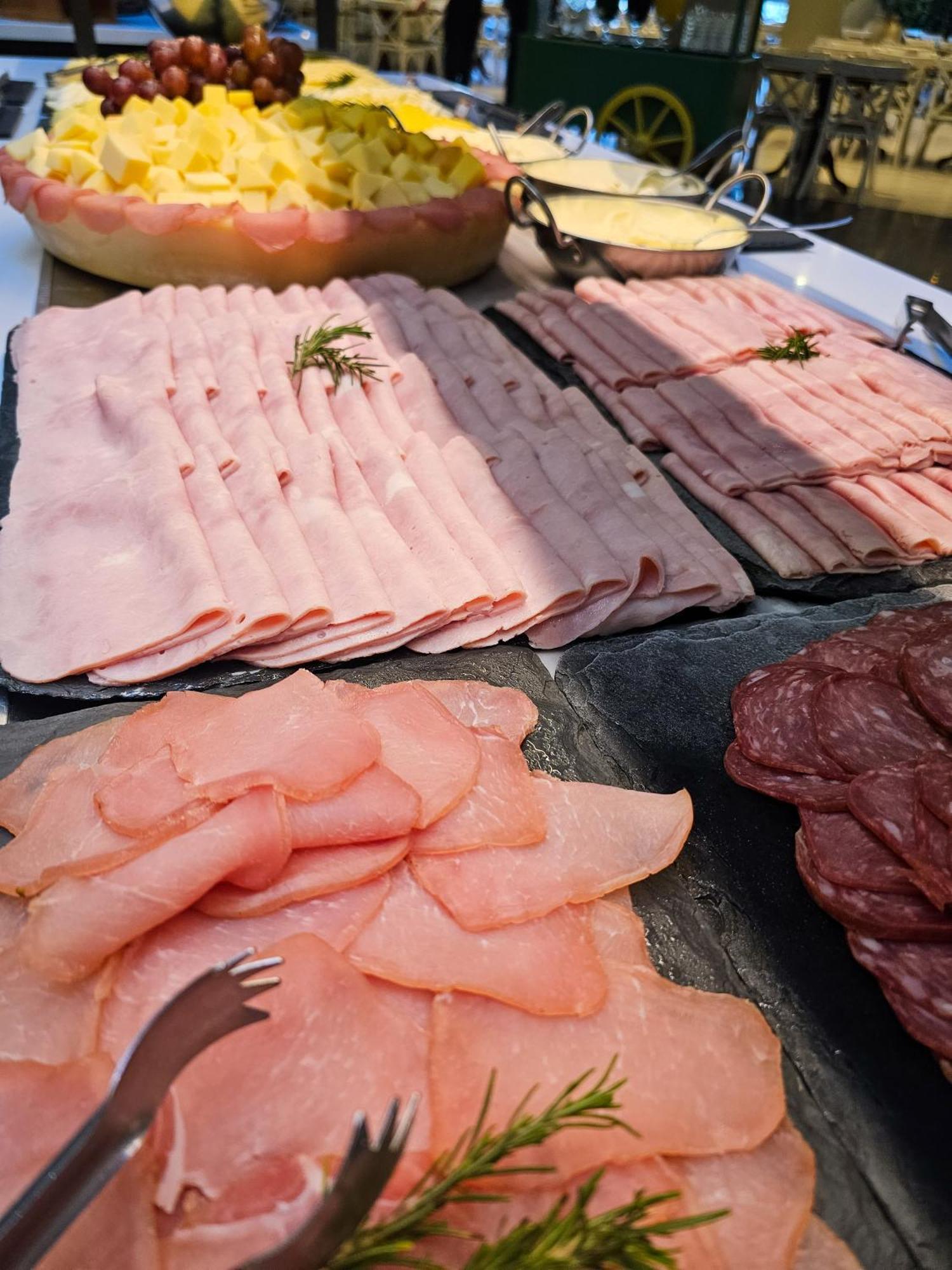 Buona Vitta Gramado Resort & Spa By Gramado Parks Zewnętrze zdjęcie The photo shows a display of various types of sliced deli meats arranged on a flat surface. There are several layers of thinly sliced, pale-colored meats, likely including ham or turkey, organized neatly in parallel rows. Additionally, there are slic